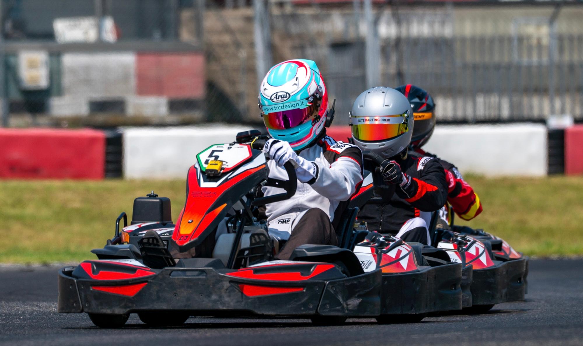 Duello ruota a ruota in pista tra kart durante una gara rental